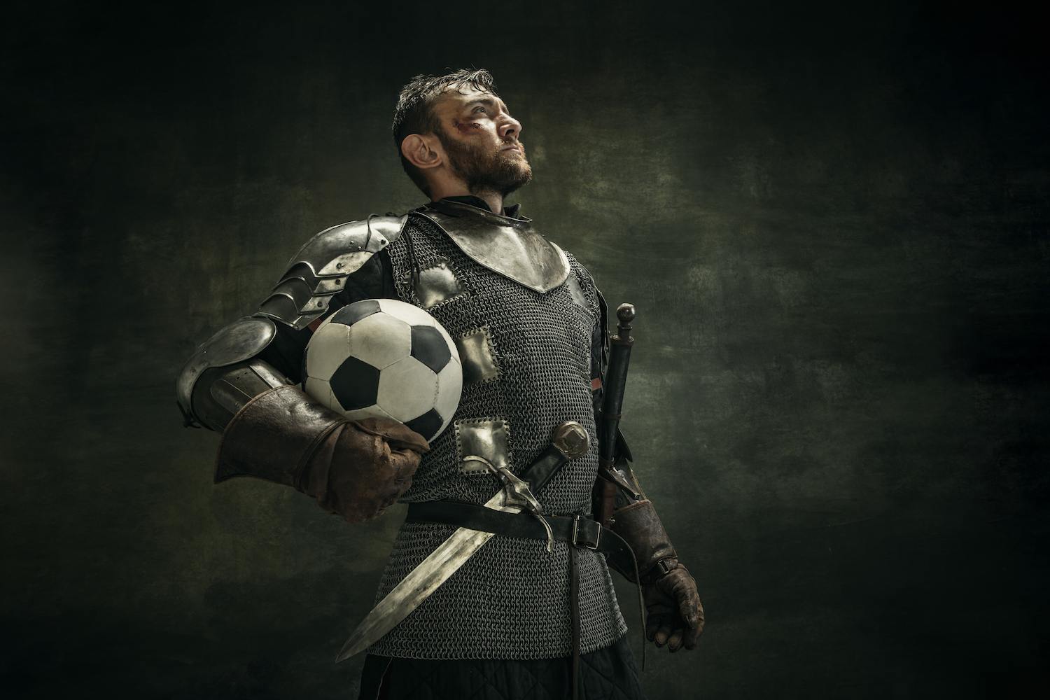 A man dressed as a knight holding a football