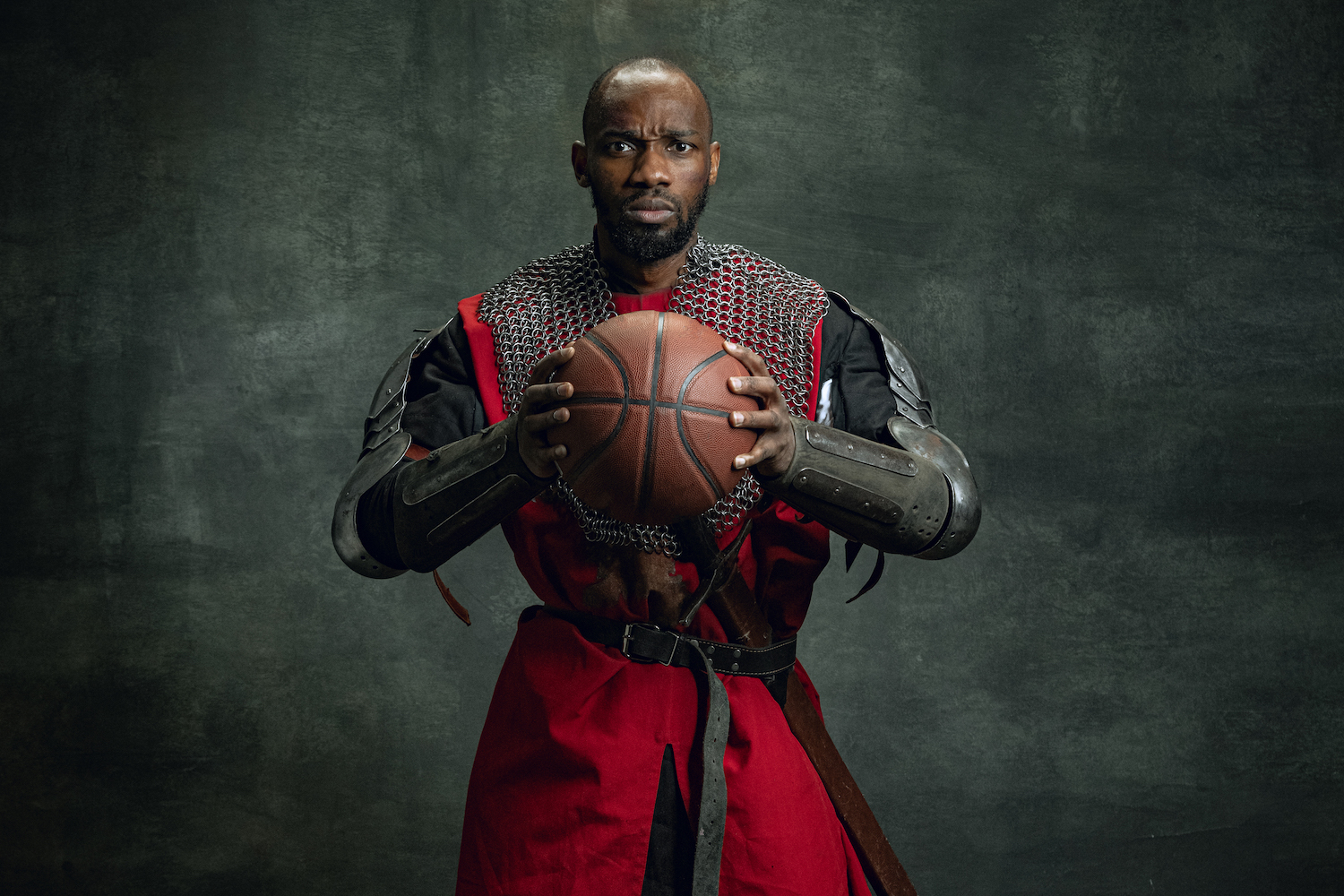 A man dressed as a knight holding a basketball