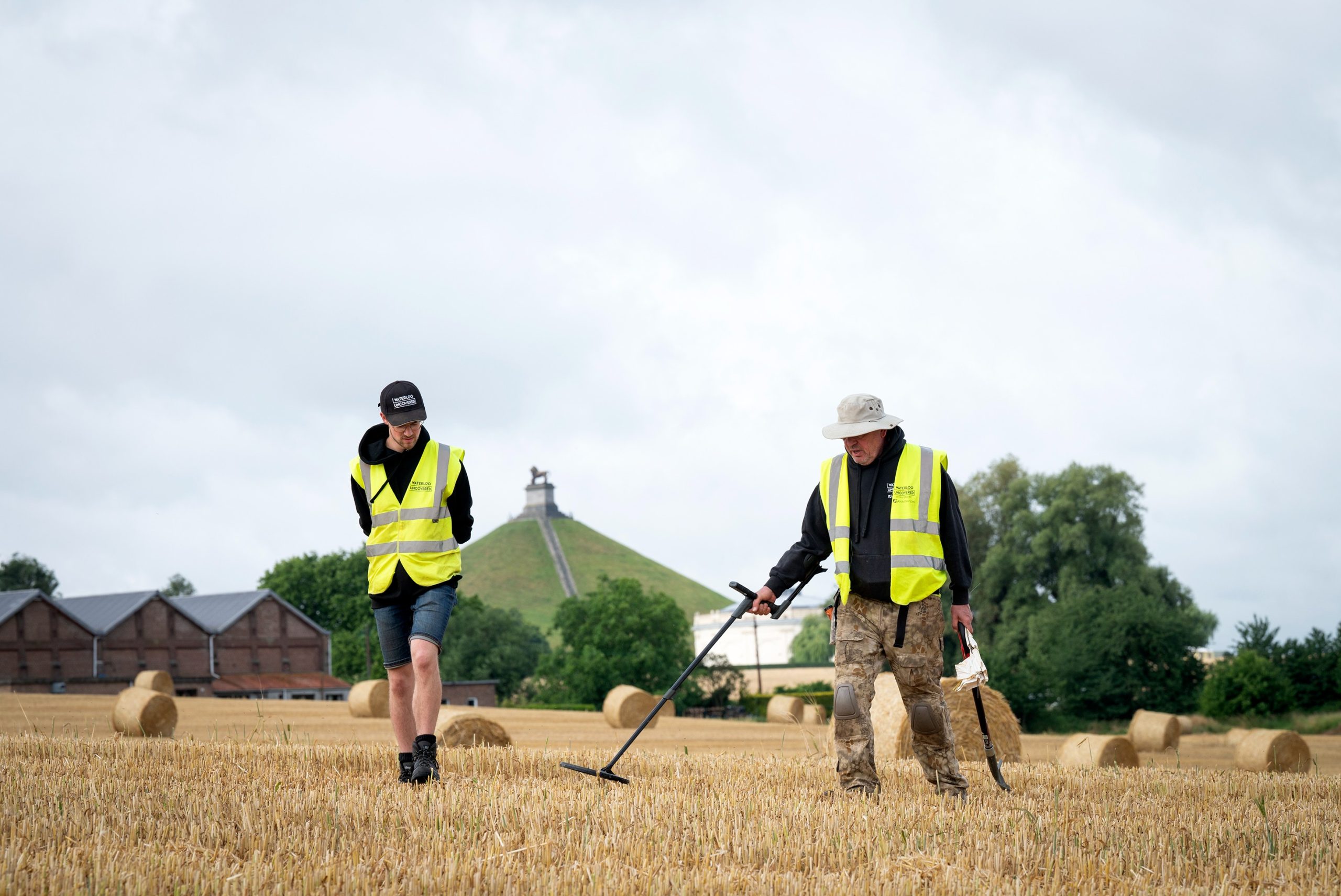 Two metal detectorists in front of the Lion's Mound on the waterloo battlefield.
